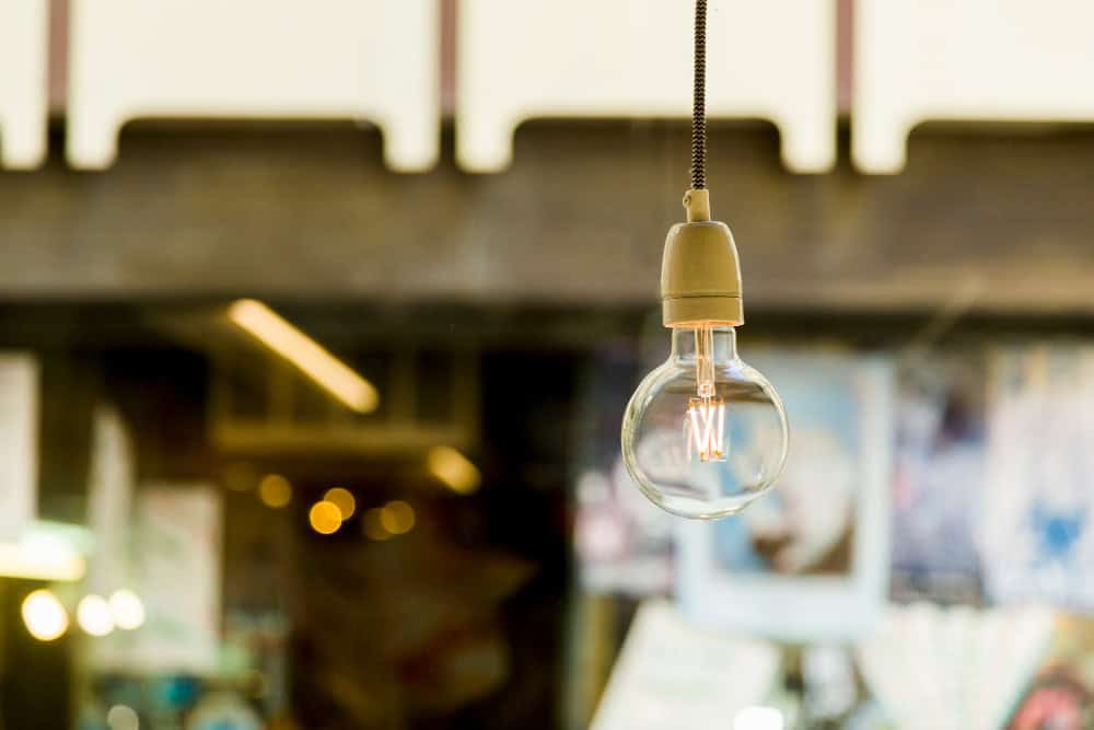 Bombilla de luz colgante en interior de oficina moderna.